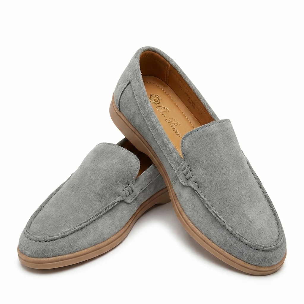 Pair of gray loafers with brown soles on a white background